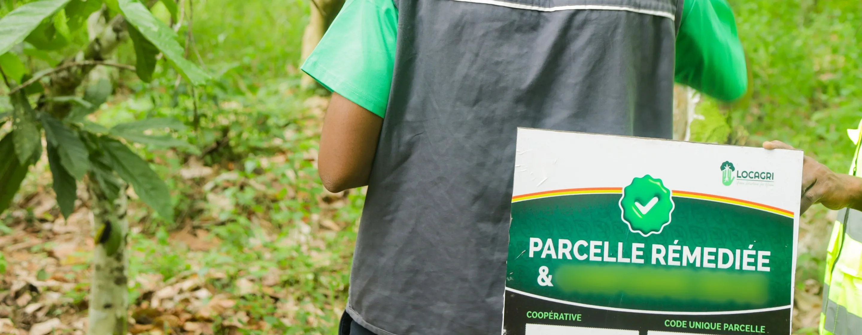 Panneau de parcelle présenté par des agents sur le terrain