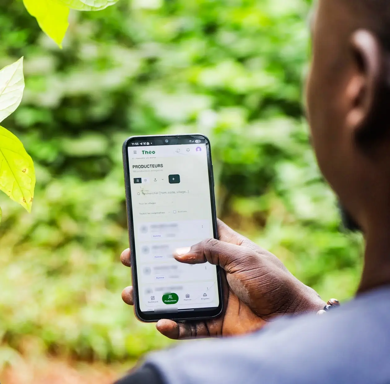 Technicien consultant la liste des producteurs dans l’application Theo sur son téléphone